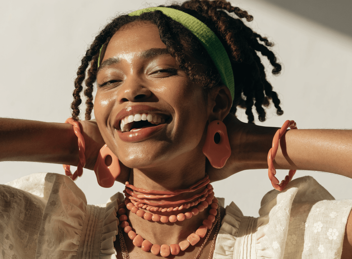 Joyful skincare campaign portrait in warm coral light